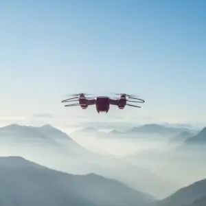 A drone flying over foggy and snowy high hills and mountains